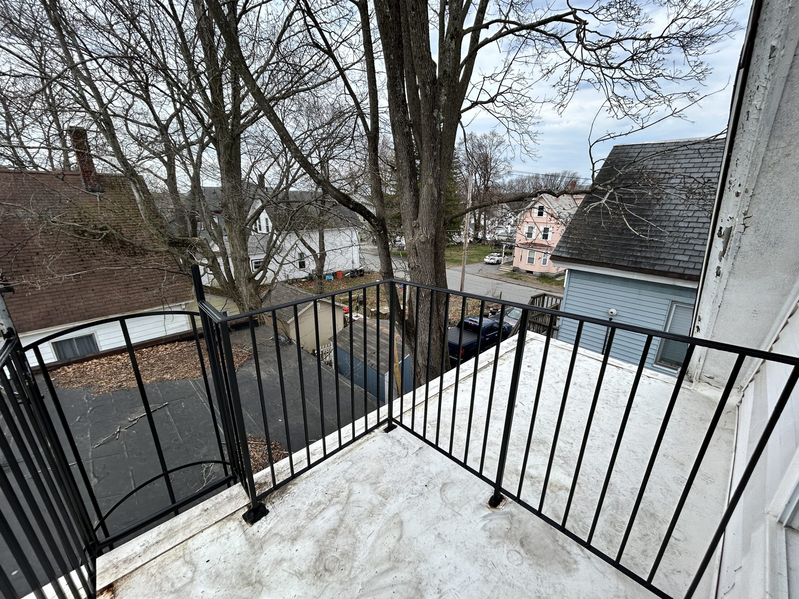 Small balcony with railing overlooking neighborhood