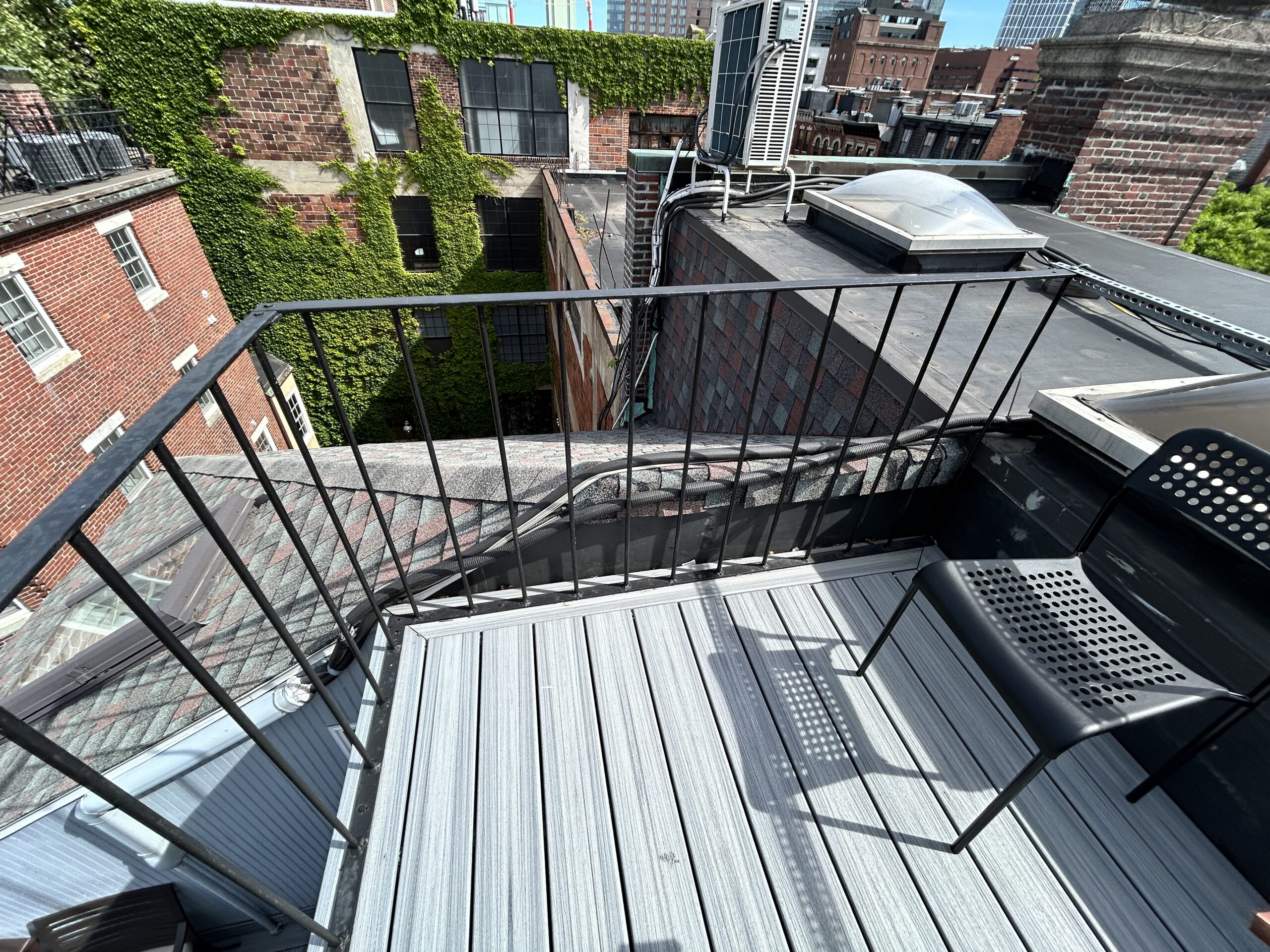 Rooftop balcony overlooking ivy-covered brick buildings