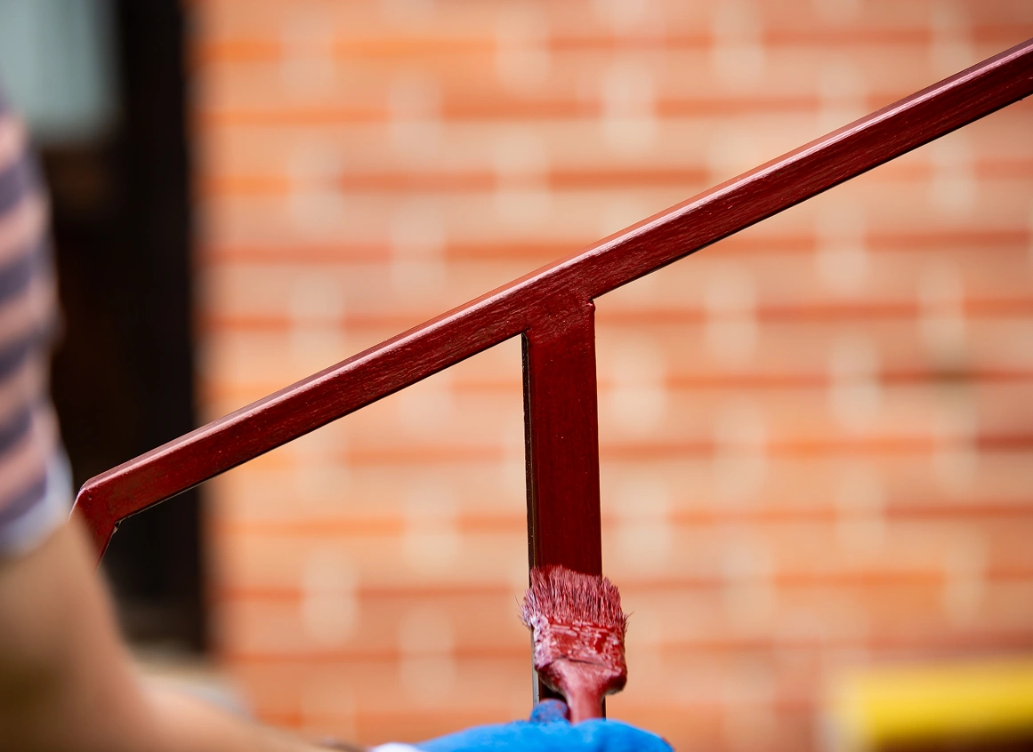 Construction work with a brush painting the fence