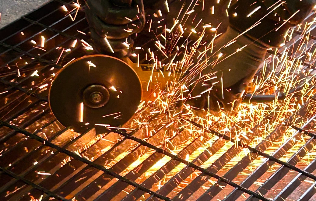 Cutting metal with angle grinder, sparks flying.