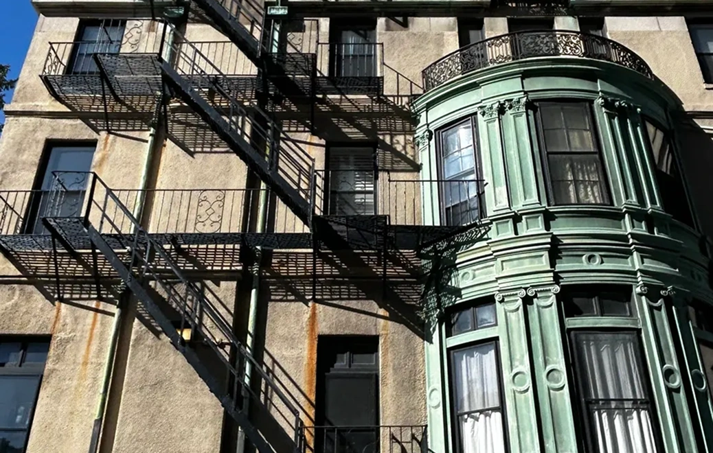 Historic building with fire escape and bay windows.